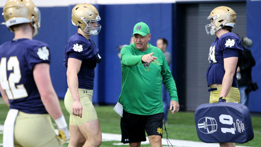 College football quarterback using helmet communication on the sideline
