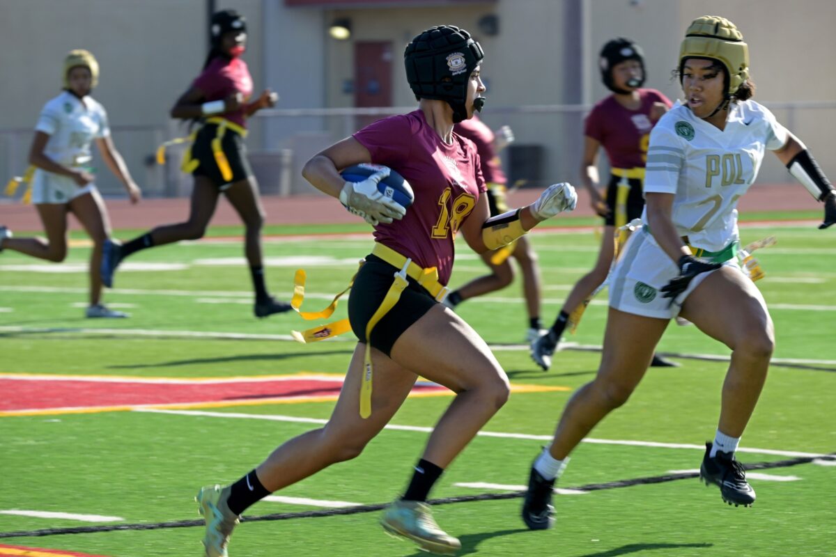 Girls varsity flag football team huddling before a game