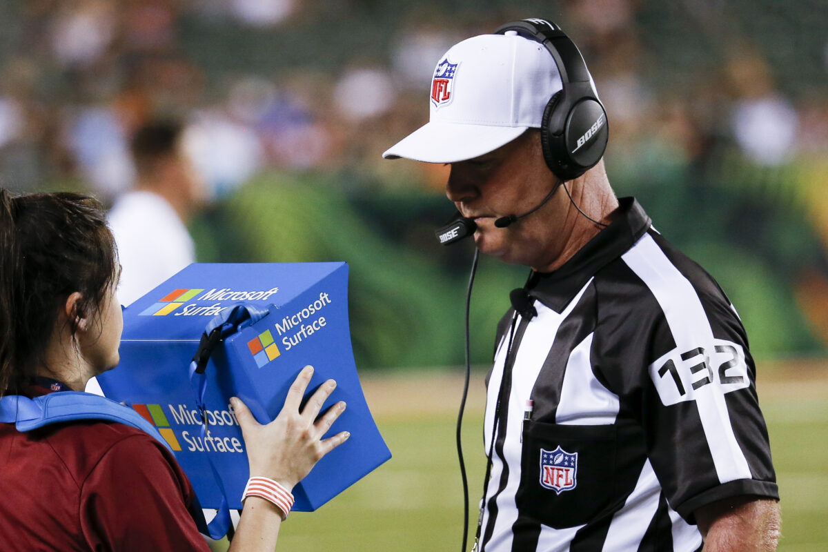 Football referee using instant replay technology during a game