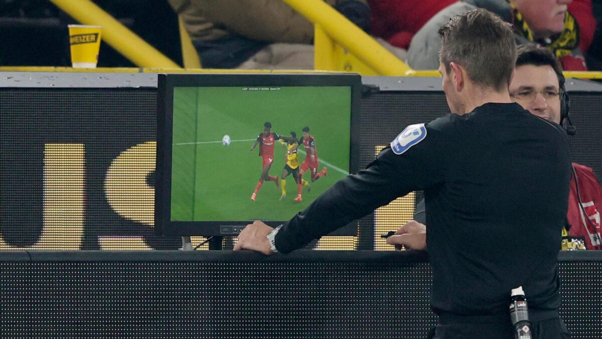 Referee announcing an instant replay decision in a football stadium