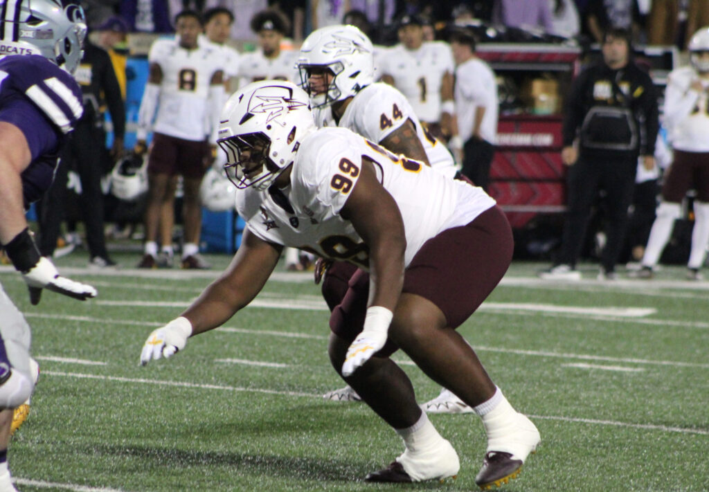 College football defender making a legal tackle on a receiver