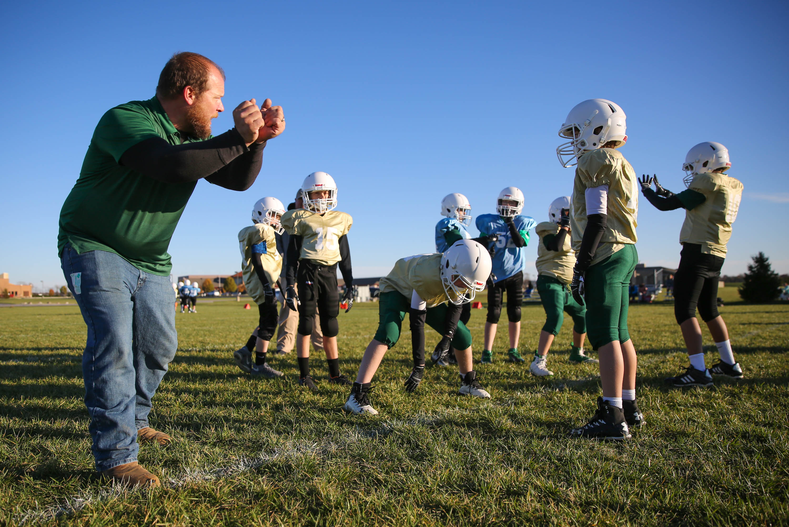 Football coach teaching tackling technique during practice
