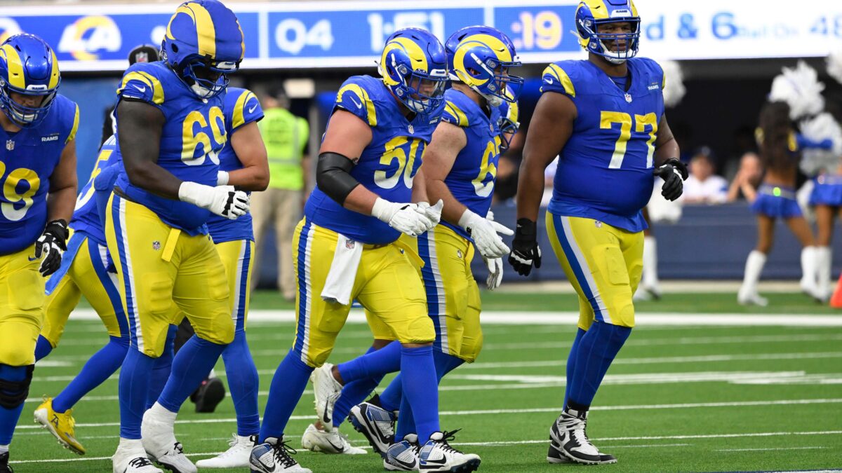 NFL offensive linemen on the sideline during a game